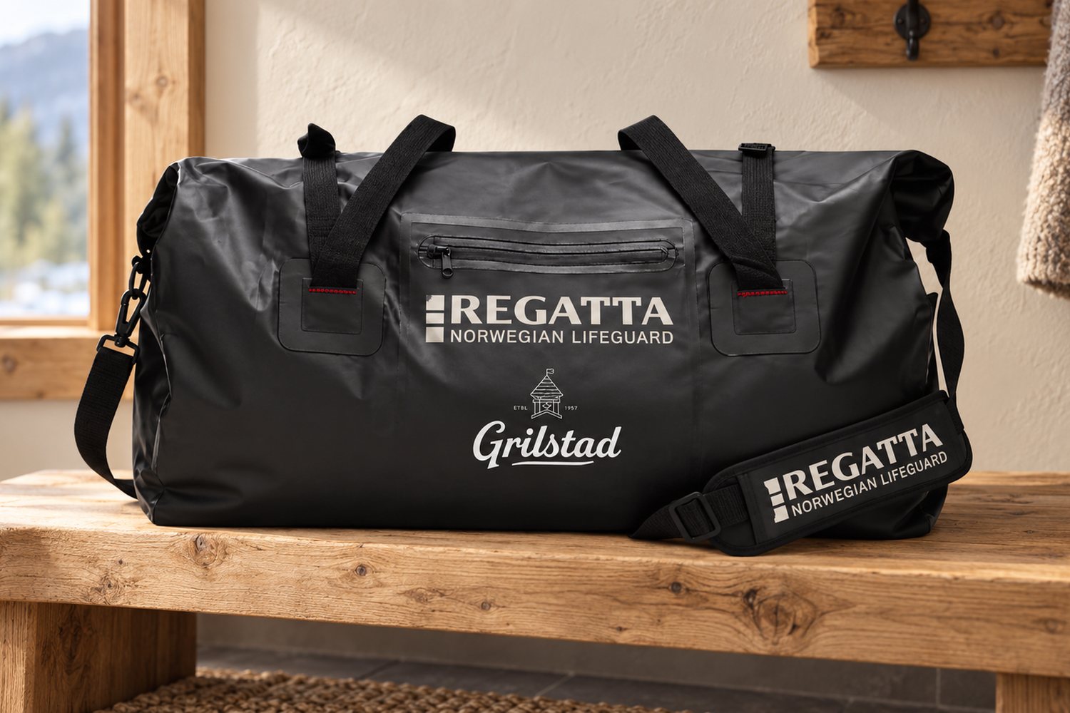 Sort duffelbag fra Regatta med hvit Grilstad-logo på en trebenk